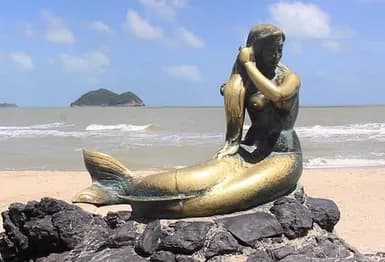 Golden Mermaid statue beside the sea at Samila Beach